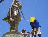 Estátua de bronze está sendo substituída com ajuda de guindaste