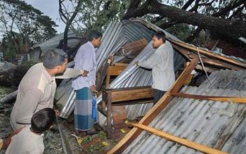 Moradores de Barishal, em Bangladesh, olham para os destroços de uma escola após passagem do ciclone 'Sidr'