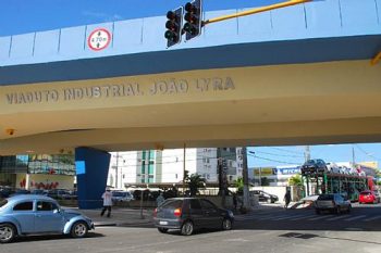 Cegonha vazia passa raspando pelo viaduto