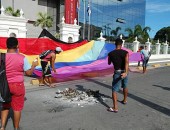 Manifestantes estendem bandeira nas grades do Palácio