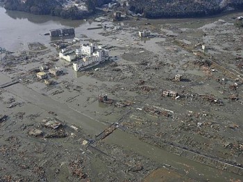 Imagem aérea da cidade portuária de Minamisanriku, coberta de lama após a passagem do tsunami, neste sábado (12)