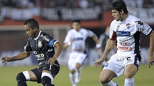 Jorge Henrique, do Corinthians, protege a bola de Marcos Miers, do Nacional-PAR