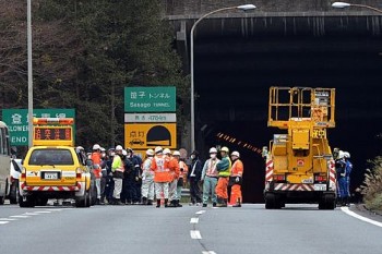 Policiais e bombeiros se concentram na entrada do túnel de Sasago neste domingo (2)