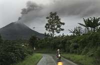 Morador deixa vilarejo nesta terça após erupções no monte Sinabung, que está ao fundo