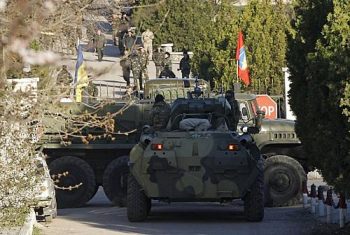 Blindado que seria de forças russas é visto na frente da entrada da base área ucraniana de Belbek neste sábado (22)