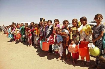 Crianças yazidi, fugidas da violência na cidade iraquiana de Sinjar, fazem fila para receber alimentos num acampamento nos arredores da província de Dohuk