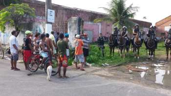 Militares do Batalhão de Policiamento Montado (RPMon) se posicionam em frente ao galpão impedindo a entrada de mais famílias no local. 