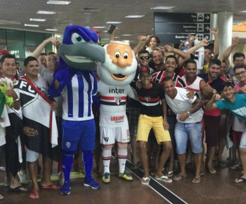 Mascote do CSA recepciona time do São Paulo em aeroporto